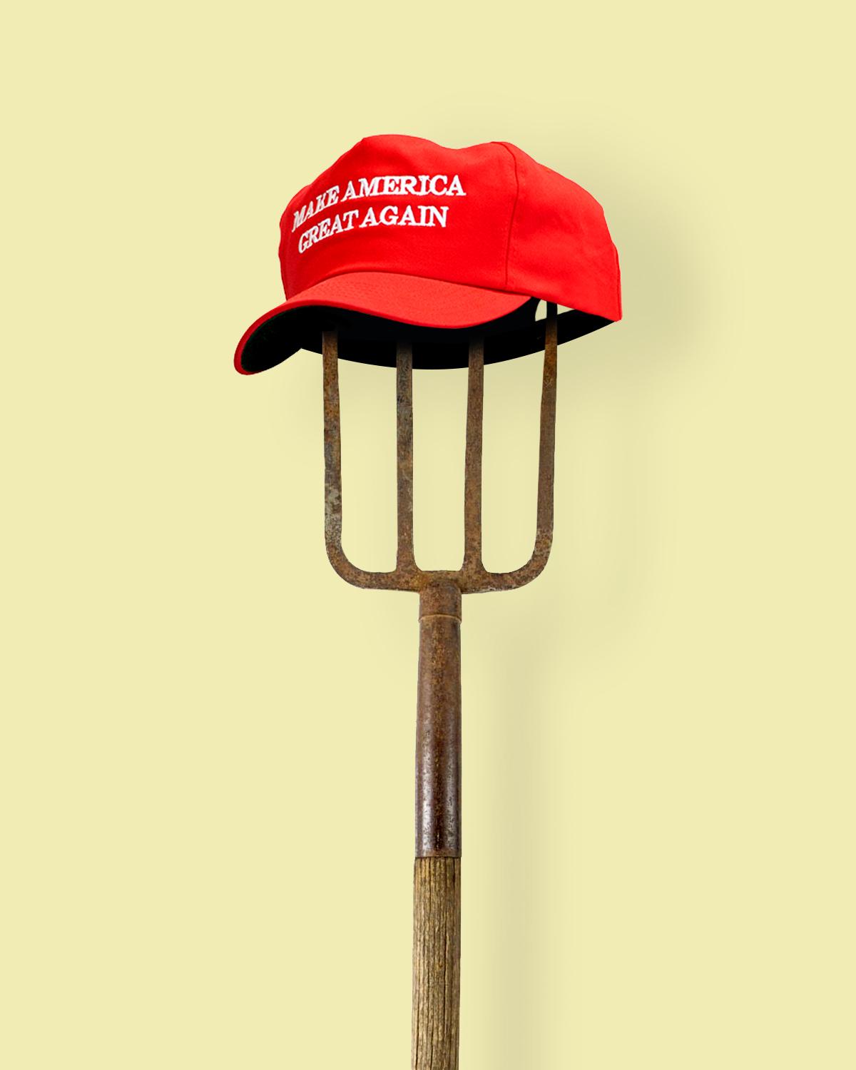 A pitchfork with a red Make America Great Again hat on top